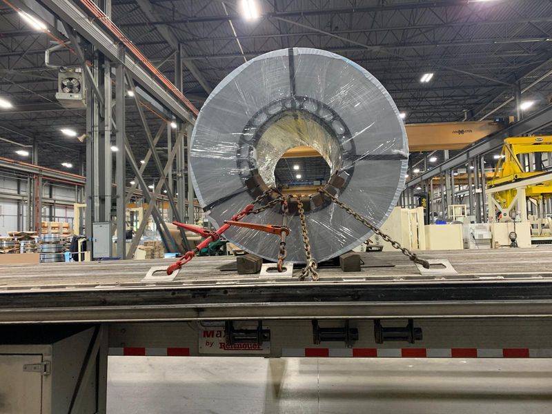Steel coil chained to a Fission flatbed inside a plant