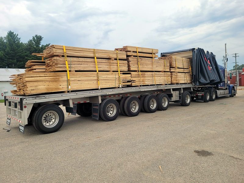 Lumber strapped on a Fission trailer, curtain rolled back